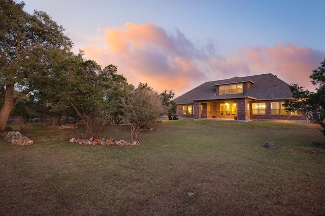 back house at dusk with a yard