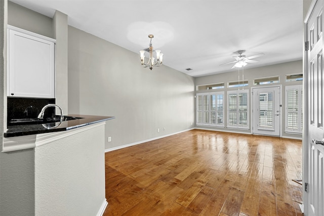 living room featuring light hardwood / wood-style flooring and ceiling fan with notable chandelier