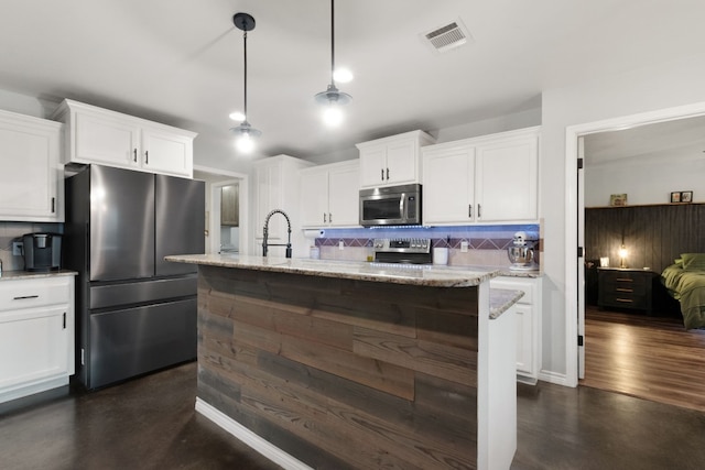 kitchen with decorative backsplash, white cabinets, decorative light fixtures, and appliances with stainless steel finishes