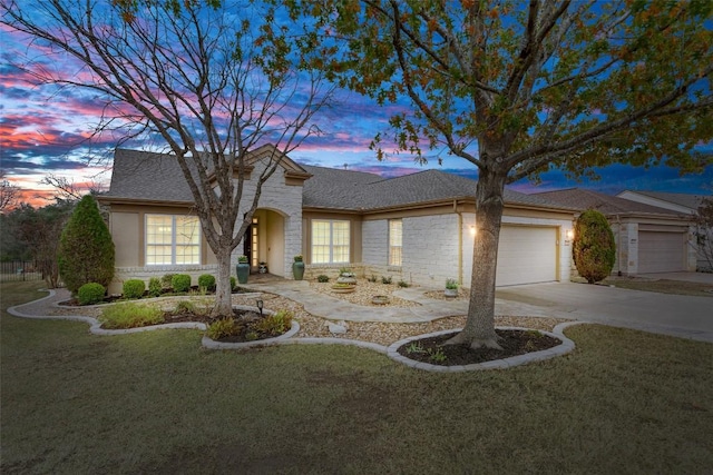 view of front of property with a garage and a yard