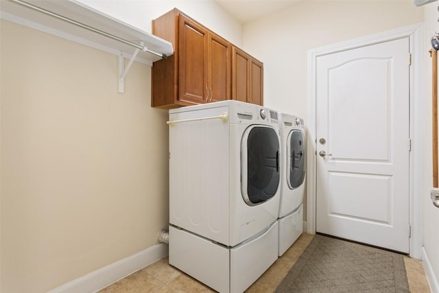 clothes washing area featuring cabinets and independent washer and dryer