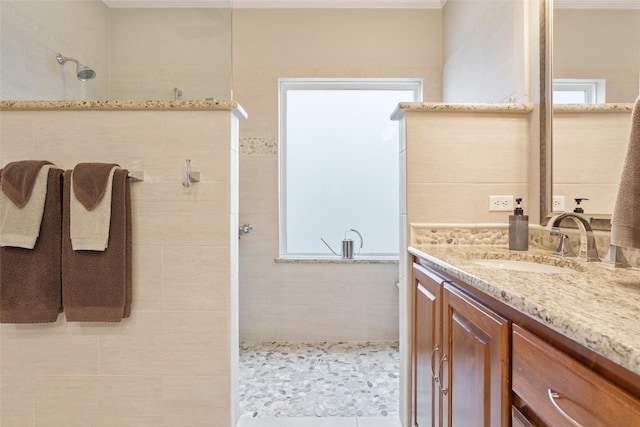 bathroom featuring a tile shower and vanity