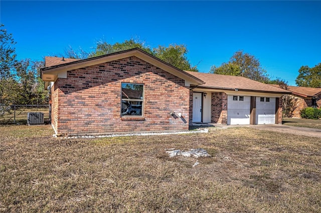 view of front of home with a front yard, a garage, and cooling unit