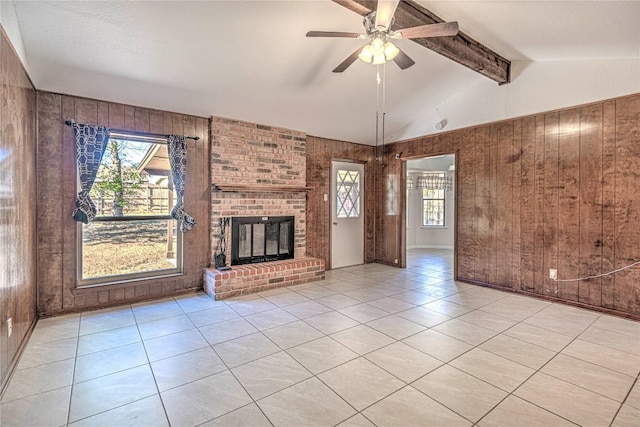 unfurnished living room with wooden walls, light tile patterned floors, and ceiling fan