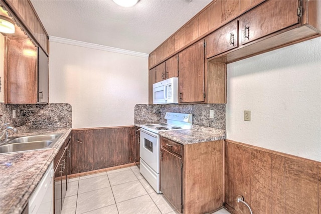 kitchen featuring sink, a textured ceiling, white appliances, light tile patterned flooring, and ornamental molding