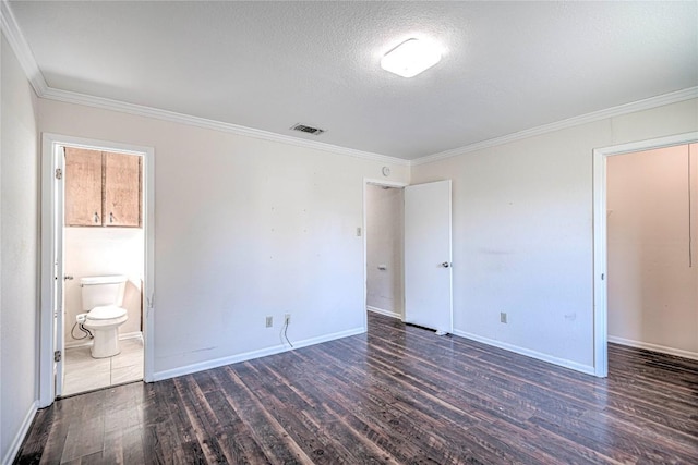 unfurnished bedroom featuring a textured ceiling, connected bathroom, dark hardwood / wood-style floors, and ornamental molding