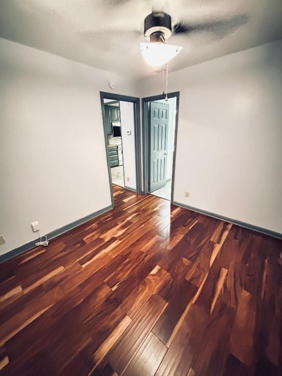 spare room featuring dark hardwood / wood-style flooring and a textured ceiling