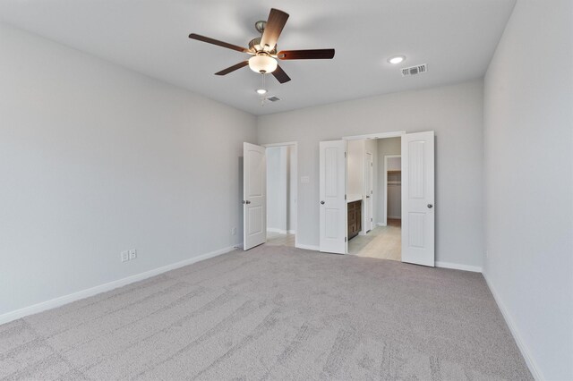 unfurnished bedroom with ceiling fan and light colored carpet