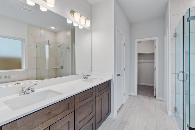 bathroom featuring vanity and a shower with door