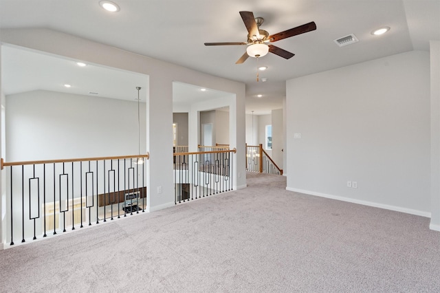 carpeted empty room with vaulted ceiling and ceiling fan