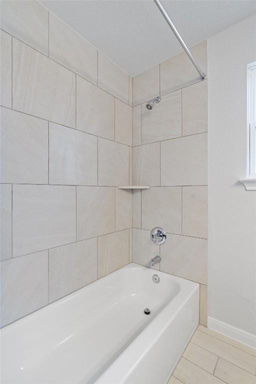 bathroom featuring tile patterned floors and tiled shower / bath