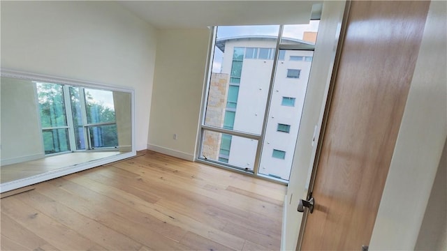 spare room featuring baseboards and hardwood / wood-style flooring