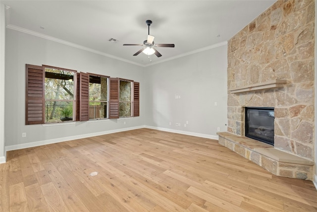 unfurnished living room with crown molding, light hardwood / wood-style flooring, a stone fireplace, and ceiling fan