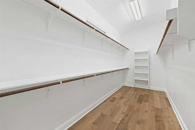 spacious closet featuring lofted ceiling and light hardwood / wood-style flooring