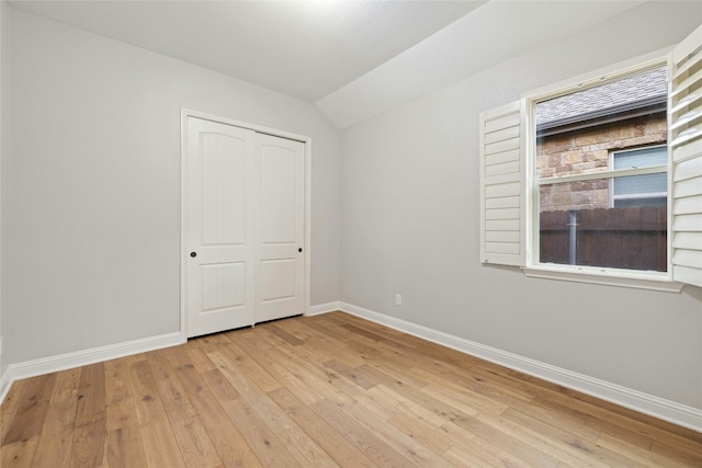 unfurnished room with lofted ceiling and light hardwood / wood-style flooring