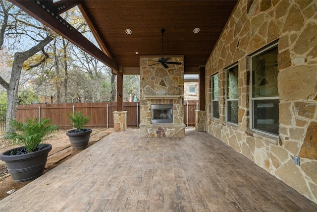 view of patio / terrace featuring ceiling fan and an outdoor stone fireplace