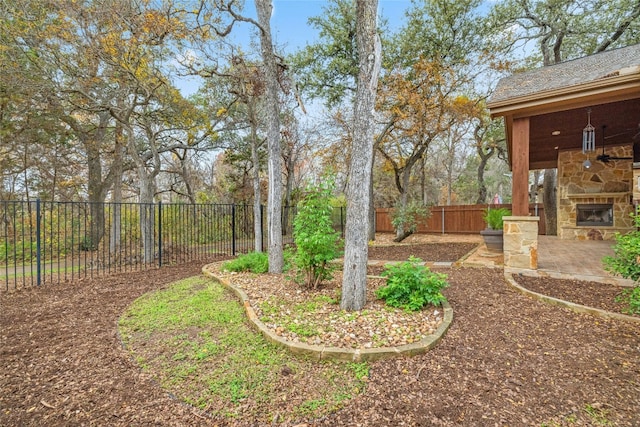 view of yard with a patio and an outdoor stone fireplace