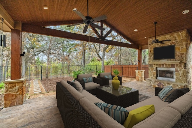 view of patio with ceiling fan and an outdoor living space with a fireplace