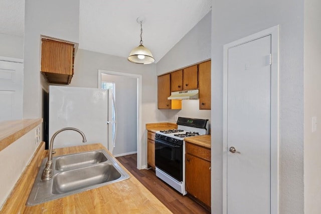 kitchen featuring pendant lighting, white appliances, sink, vaulted ceiling, and dark hardwood / wood-style floors