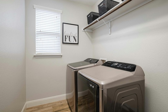 laundry area with independent washer and dryer and light hardwood / wood-style floors