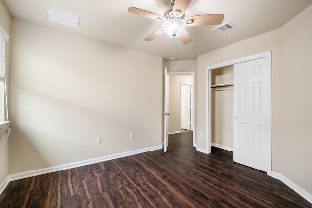 unfurnished bedroom with ceiling fan, dark hardwood / wood-style floors, and a closet