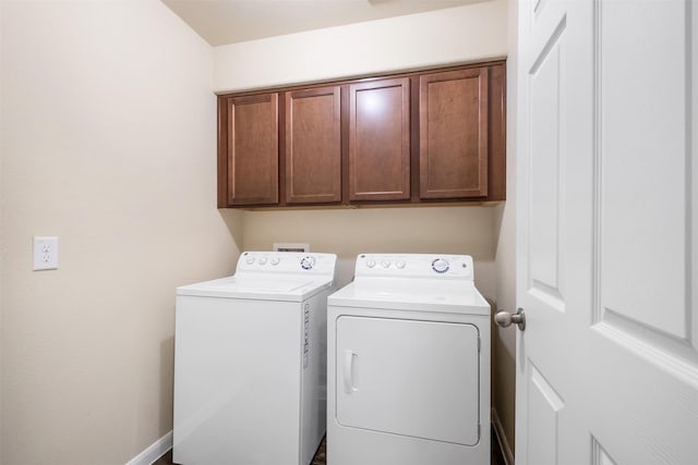 laundry room featuring washer and dryer and cabinets