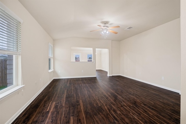 empty room with ceiling fan, a healthy amount of sunlight, and dark wood-type flooring