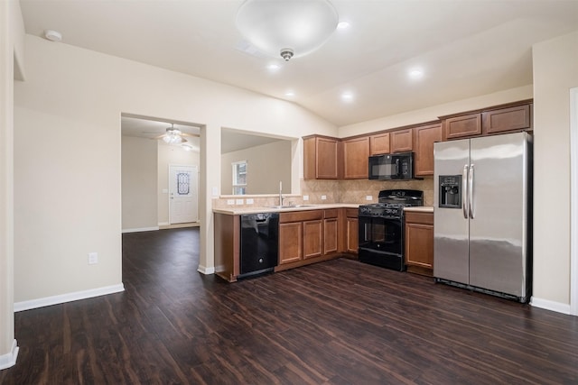 kitchen with tasteful backsplash, lofted ceiling, black appliances, sink, and dark hardwood / wood-style flooring