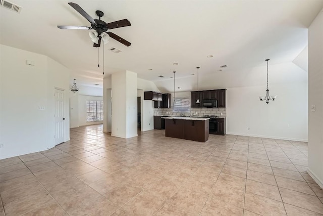 kitchen featuring decorative backsplash, a kitchen island, light tile patterned flooring, and hanging light fixtures