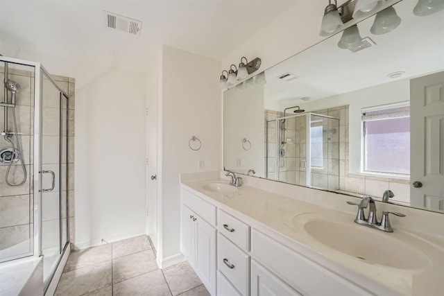 bathroom featuring tile patterned flooring, vanity, and a shower with shower door