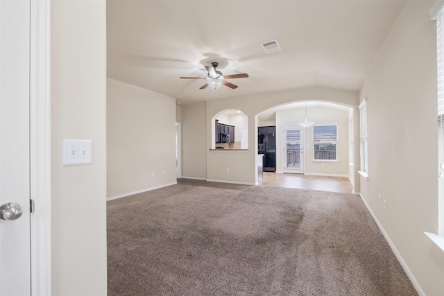 unfurnished living room with ceiling fan, vaulted ceiling, and carpet flooring