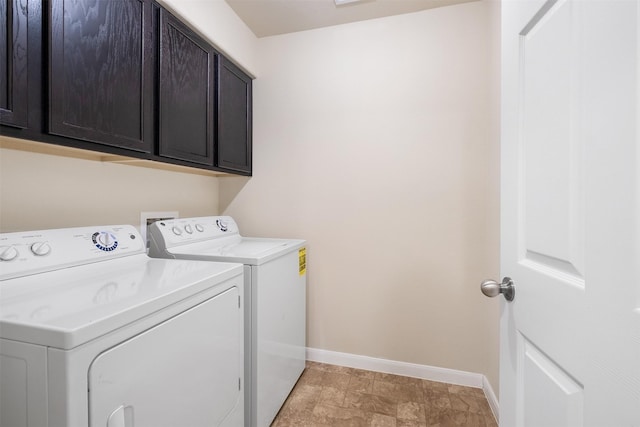 clothes washing area with cabinets and washing machine and clothes dryer