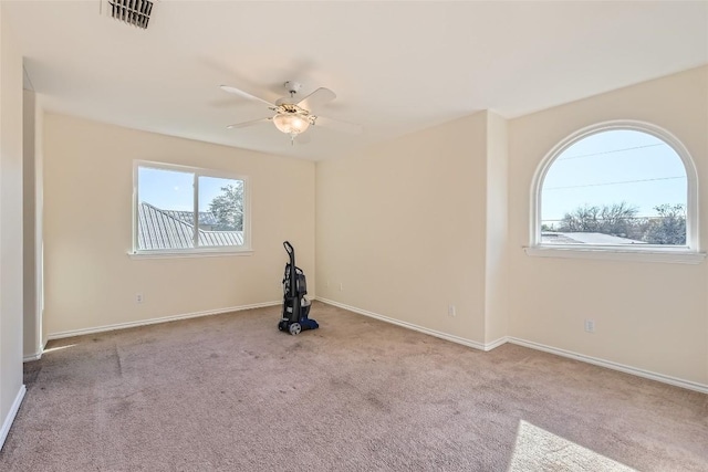 carpeted spare room featuring ceiling fan