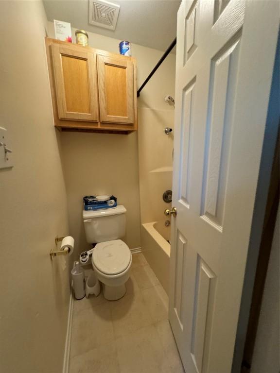 bathroom featuring tile patterned floors, bathtub / shower combination, and toilet