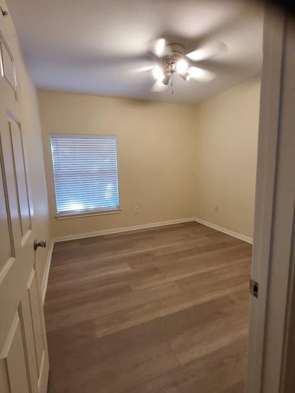 empty room with ceiling fan and dark wood-type flooring