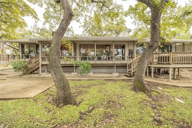 rear view of house featuring a sunroom