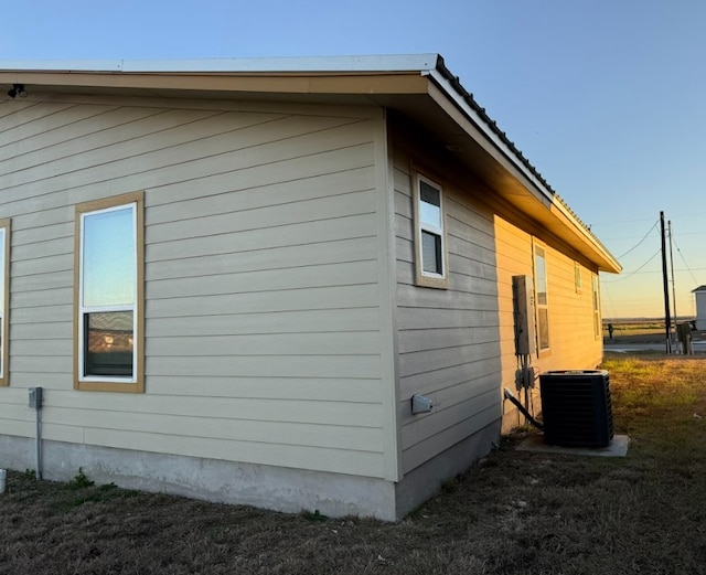 property exterior at dusk featuring cooling unit