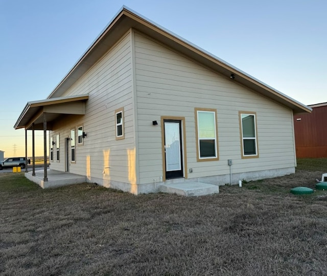 back house at dusk featuring a patio area