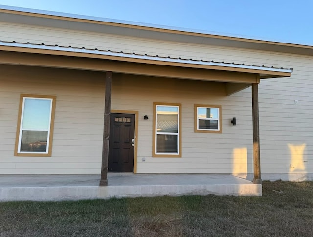 view of exterior entry featuring a patio