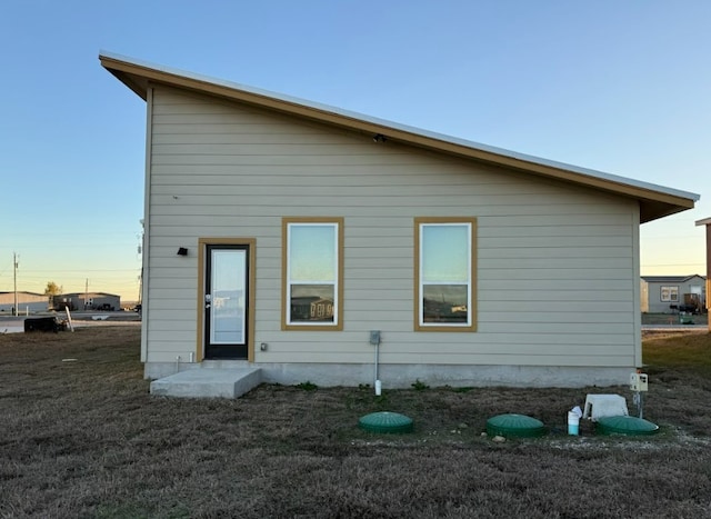 427 Pintail Loop, San Marcos, TX 78666 - back of property at dusk featuring a yard