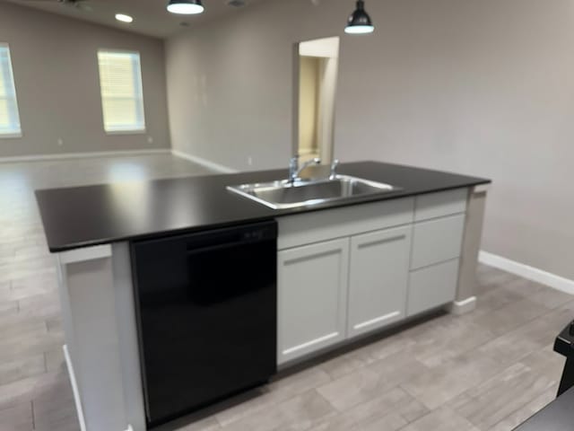 kitchen with dishwasher, sink, vaulted ceiling, decorative light fixtures, and white cabinets