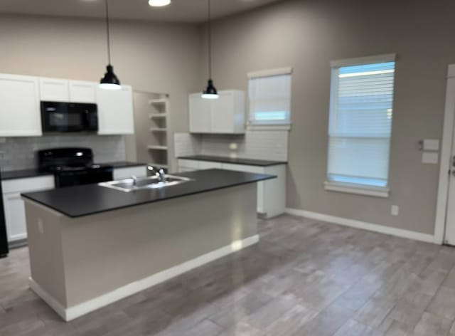 427 Pintail Loop, San Marcos, TX 78666 - kitchen with black microwave, stove, dark countertops, backsplash, and white cabinetry