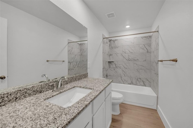 full bathroom with hardwood / wood-style flooring, vanity, toilet, and tiled shower / bath