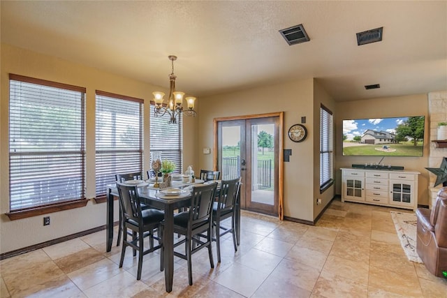 dining area featuring a chandelier, light tile patterned floors, and a textured ceiling