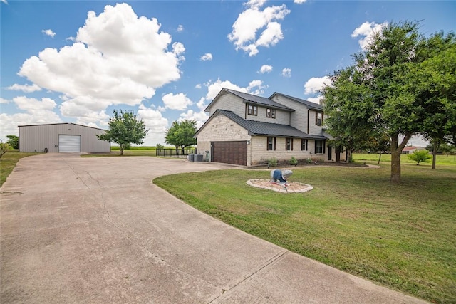 view of front of property featuring a front yard, central AC, and a garage