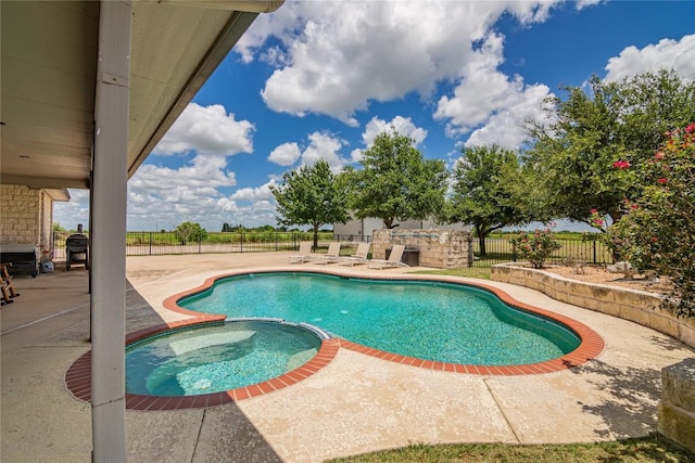 view of pool with a patio area and an in ground hot tub