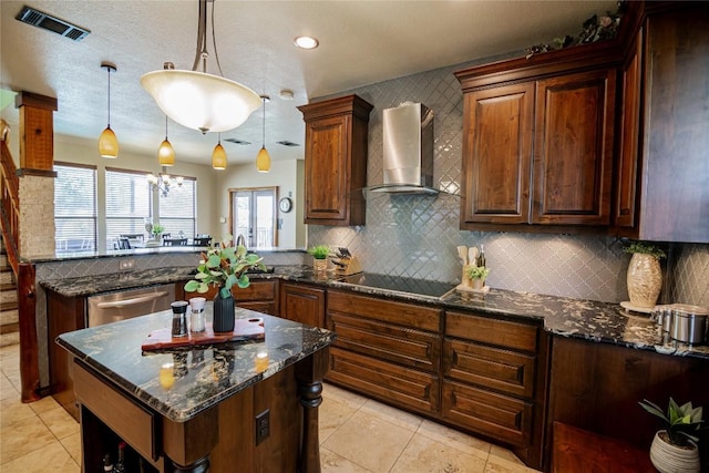 kitchen with wall chimney range hood, tasteful backsplash, dark stone counters, decorative light fixtures, and black electric cooktop