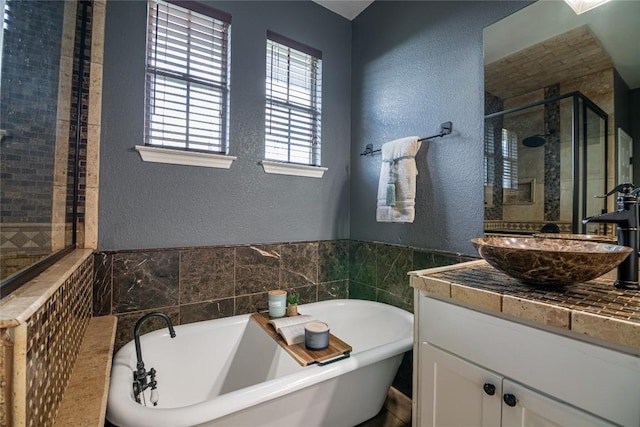 bathroom featuring vanity and independent shower and bath