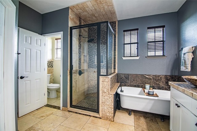 full bathroom featuring vanity, toilet, and independent shower and bath