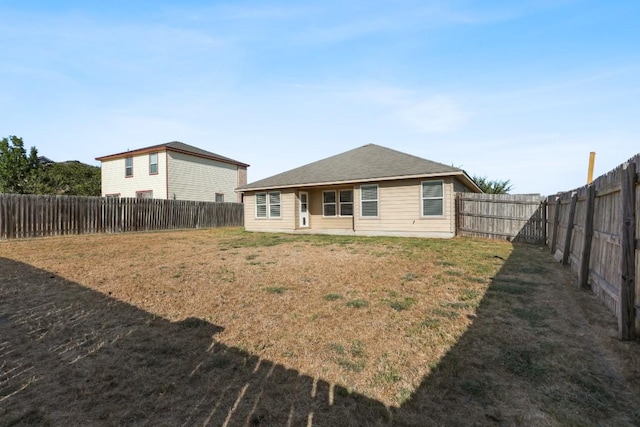 rear view of house featuring a yard